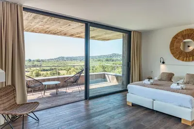 a bedroom with a bed and a balcony at Villa Fautea Di Santa Lucia in Sainte-Lucie de Porto-Vecchio