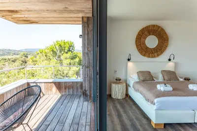 a bedroom with a bed and a balcony with a view at Villa Fautea Di Santa Lucia in Sainte-Lucie de Porto-Vecchio