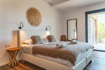 a bedroom with a bed with towels on it at Villa Fautea Di Santa Lucia in Sainte-Lucie de Porto-Vecchio