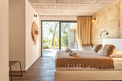a bedroom with a bed and a large glass door at Villa Fautea Di Santa Lucia in Sainte-Lucie de Porto-Vecchio