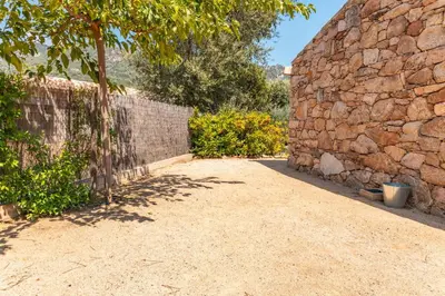 a stone wall next to a dirt road at Villa Cupulatta Di Santa Lucia in Sainte-Lucie de Porto-Vecchio