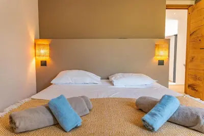 a bedroom with a bed with two blue pillows on the floor at Villa Cupulatta Di Santa Lucia in Sainte-Lucie de Porto-Vecchio