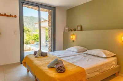 a bedroom with a large bed and a large window at Villa Cupulatta Di Santa Lucia in Sainte-Lucie de Porto-Vecchio