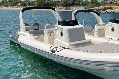 a white pontoon boat sitting in the water at Villa Cupulatta Di Santa Lucia in Sainte-Lucie de Porto-Vecchio