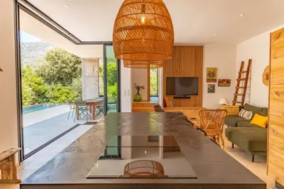 a kitchen and living room with a view of a pool at Villa Cupulatta Di Santa Lucia in Sainte-Lucie de Porto-Vecchio