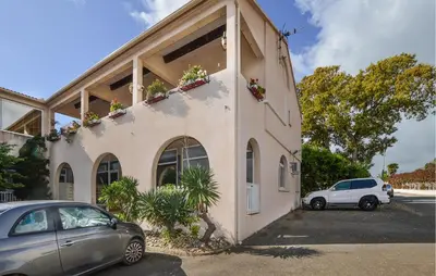a building with a car parked in a parking lot at 2 Bedroom Cozy Apartment In Prunete in Prunete