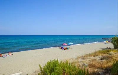 a beach with people laying on the sand and the ocean at 2 Bedroom Cozy Apartment In Prunete in Prunete