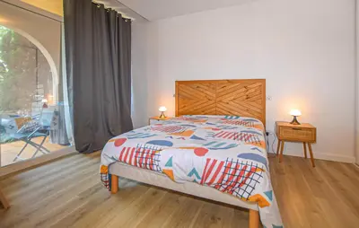 a bedroom with a bed with a wooden headboard and a window at 2 Bedroom Cozy Apartment In Prunete in Prunete