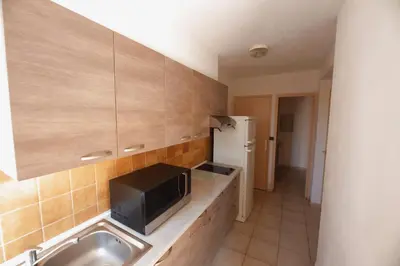 a kitchen with a sink and a tv on a counter at Casa l'Ascosu 2 in Coggia
