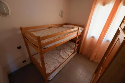 a bunk bed room with two bunk beds and a window at Casa l'Ascosu 2 in Coggia