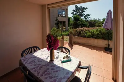 a table with a vase of flowers on top at Casa l'Ascosu 2 in Coggia