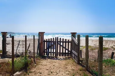 a gate at the beach with the ocean in the background at Casa l'Ascosu 2 in Coggia