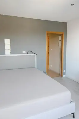 a white bed in a room with a hallway at Evasion Méditerranée - Vue Mer in Ajaccio