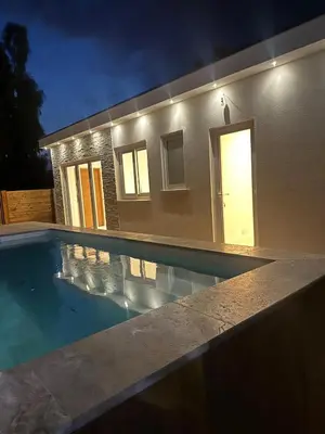 a swimming pool in front of a house at night at villa louise in Calenzana