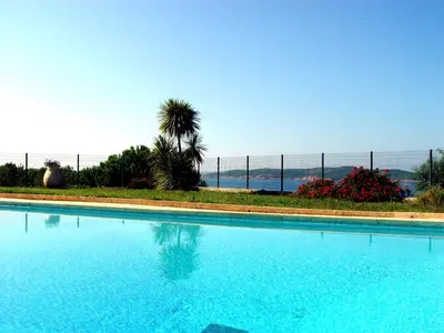 a blue swimming pool with a fence in the background at Résidence Ellada 3 Appartement 12 in Cargèse