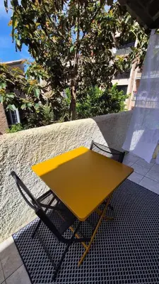 a kitchen with a counter top and a living room at Studio with sea view in Calcatoggio