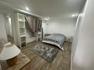 a bedroom with a bed and a lamp on a wooden floor at Appartement proche de la rivière et de la plage ! in Vico