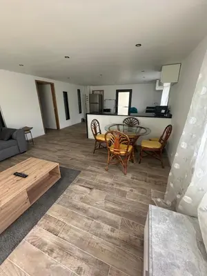a living room with a table and chairs at Appartement proche de la rivière et de la plage ! in Vico
