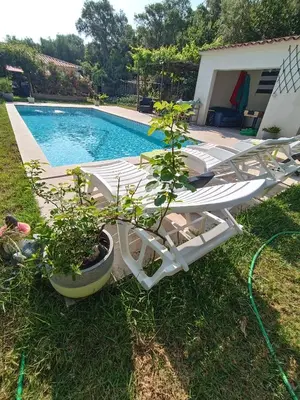 a swimming pool with a white lounge chair next to a swimming pool at Chalet et Mobile Home, au sein du maquis Corse avec piscine PRIVATIVE 9mx4m in Zonza