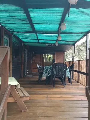 a screened porch with a blue tarp on it at Chalet et Mobile Home, au sein du maquis Corse avec piscine PRIVATIVE 9mx4m in Zonza