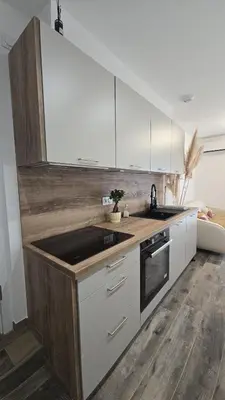 a kitchen with white cabinets and a counter top at Appartement T2 moderne 2 à 4 personnes in Lucciana