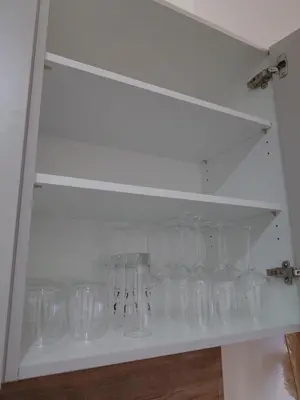 a shelf filled with empty glasses in a room at Appartement T2 moderne 2 à 4 personnes in Lucciana