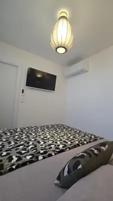 a bedroom with a black and white bed with a light at Appartement T2 moderne 2 à 4 personnes in Lucciana