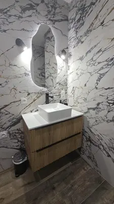 a bathroom with a sink and a marble wall at Appartement T2 moderne 2 à 4 personnes in Lucciana