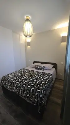 a bedroom with a bed with a black and white comforter at Appartement T2 moderne 2 à 4 personnes in Lucciana