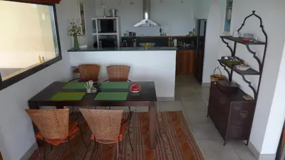a dining room with a table and chairs and a kitchen at Villa Panorama Porto-Vecchio in Porto-Vecchio