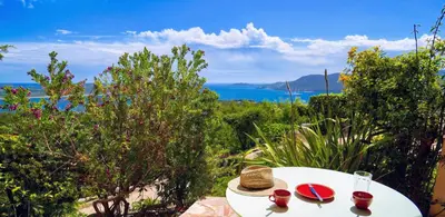 a white table with red plates and glasses on it at Villa Panorama Porto-Vecchio in Porto-Vecchio