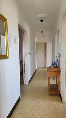 a hallway with a room with a table and a door at Grand appartement Vescovato entre mer et montagne in Vescovato