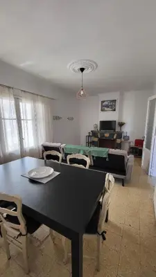 a living room with a table and chairs and a couch at Grand appartement Vescovato entre mer et montagne in Vescovato