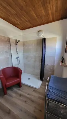 a bathroom with a shower with a red chair and a tub at Grand appartement Vescovato entre mer et montagne in Vescovato