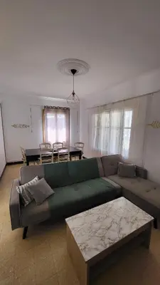 a living room with a green couch and a table at Grand appartement Vescovato entre mer et montagne in Vescovato