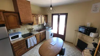 a kitchen with a table and a sink and a stove at Grand appartement Vescovato entre mer et montagne in Vescovato