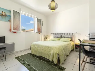 a bedroom with a bed and a desk and a television at Apartment Albarella by Interhome in Vescovato