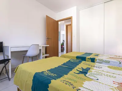 a bedroom with two beds and a desk and a chair at Apartment Albarella by Interhome in Vescovato