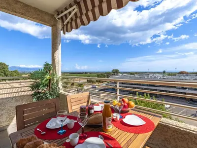 a table with food and wine glasses on a balcony at Apartment Albarella by Interhome in Vescovato