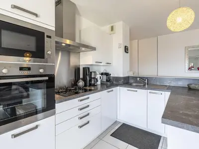 a kitchen with white cabinets and a stove top oven at Apartment Albarella by Interhome in Vescovato