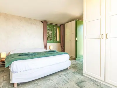 a bedroom with a white bed and a window at Holiday Home Casa Murato by Interhome in San-Giuliano