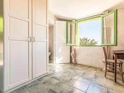 a room with a door and a window and a table at Holiday Home Casa Murato by Interhome in San-Giuliano