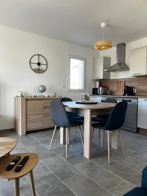 a kitchen and dining room with a table and chairs at Appartement T2 neuf résidence U Scalu in Santa-Lucia-di-Moriani