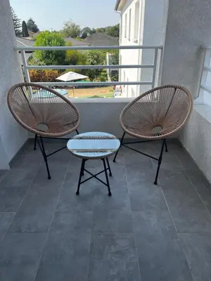 two chairs and a table on a balcony at Appartement T2 neuf résidence U Scalu in Santa-Lucia-di-Moriani