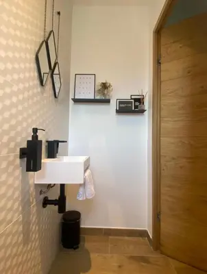 a bathroom with a white sink next to a door at Villa 4 chambres à Castirla in Castirla
