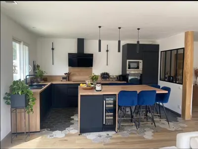 a kitchen with black cabinets and blue bar stools at Villa 4 chambres à Castirla in Castirla