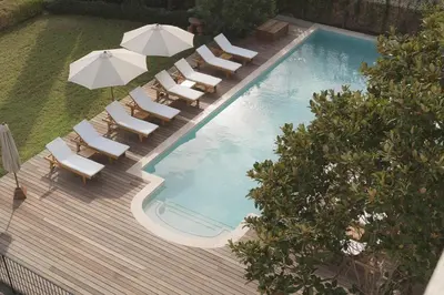 an apartment building with balconies and a tree at Hôtel & Spa Best Western Premier A Storia Solenzara in Sari Solenzara