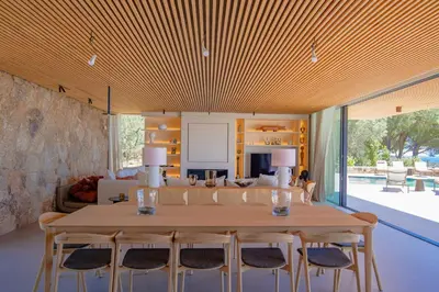 a dining room and living room with a table and chairs at Villa Lucia Di Arinella in Pinarellu