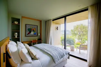 a bedroom with a large bed and a large window at Villa Lucia Di Arinella in Pinarellu