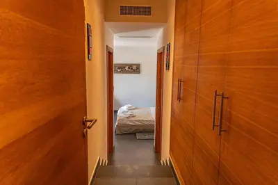 a hallway with wooden doors and a bed in a bedroom at Casa Carolina Di Palombaggia in Porto-Vecchio
